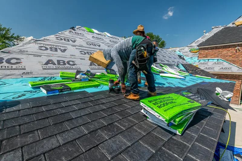 Roofing contractor installing materials on residential roof